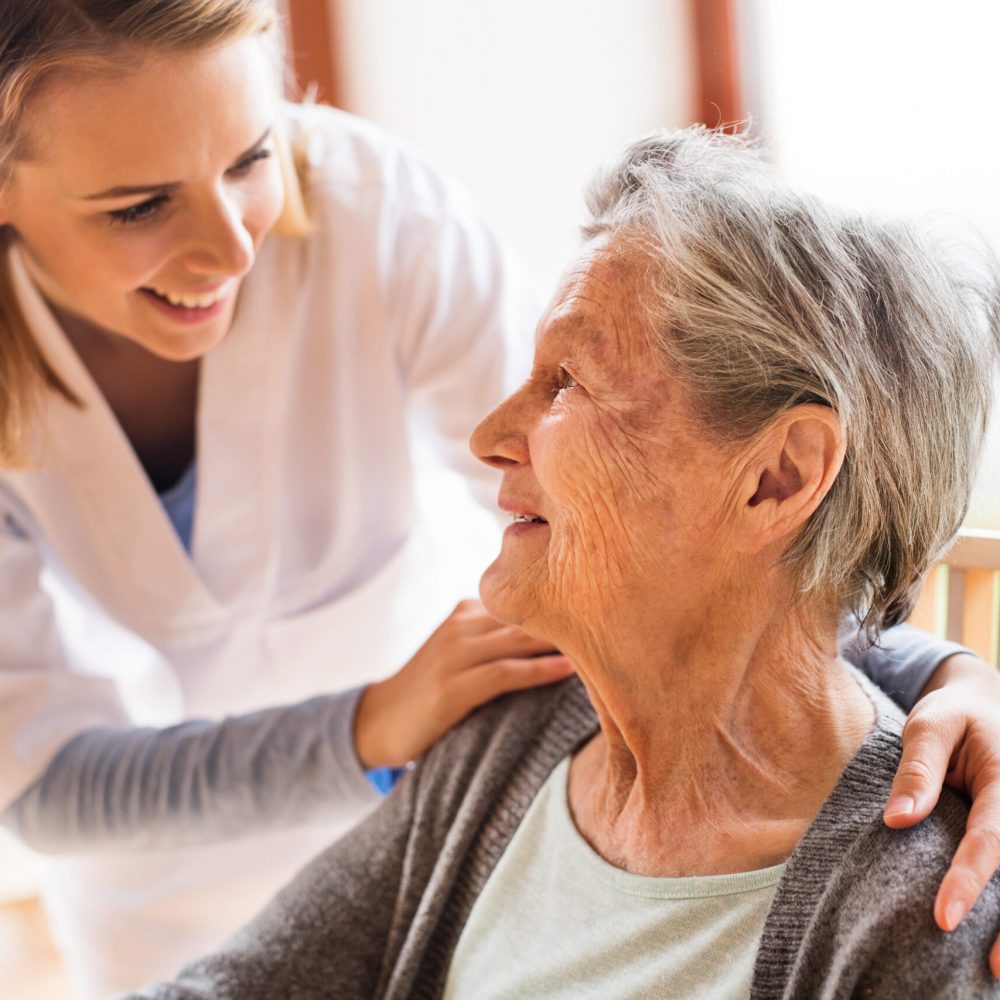 Health visitor and a senior woman during home visit. Health visitor and a senior woman during home visit. A nurse talking to an elderly woman.